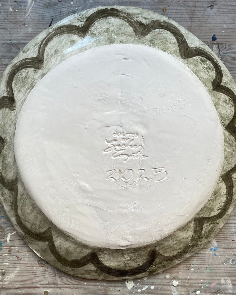 Round white object with a design on a textured surface