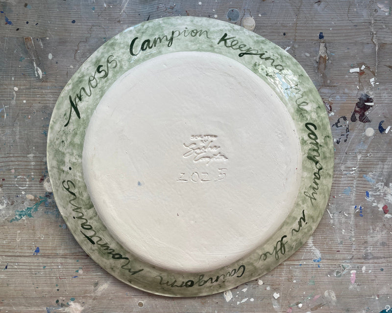 Ceramic plate with engraved text on a textured surface