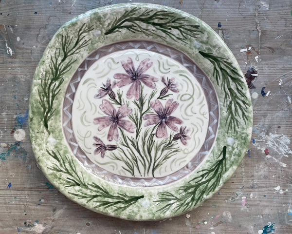 Decorative plate with floral design on a textured surface