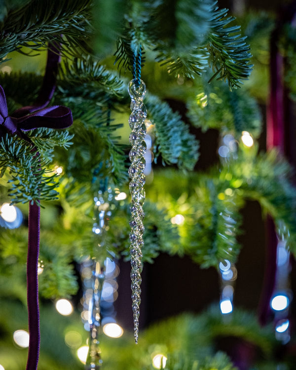 Decorative Christmas tree with purple ribbons and hanging crystal decorations.