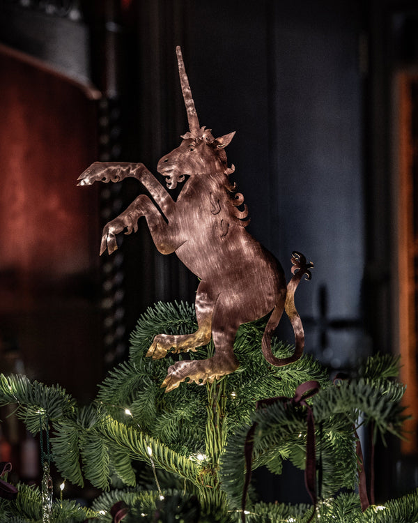 Decorative unicorn figurine on a Christmas tree with a dark background