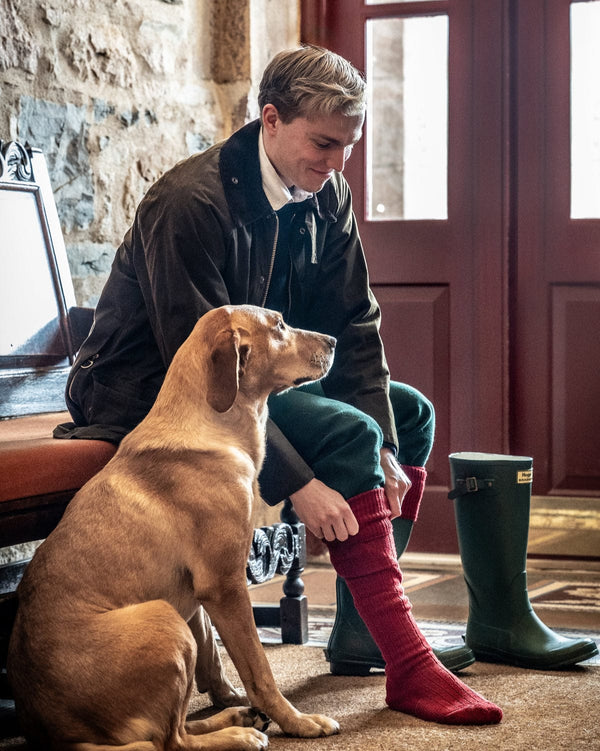 Man with a dog sitting on the floor in front of a door.