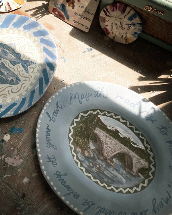 Two ceramic plates with artistic designs on a wooden surface.
