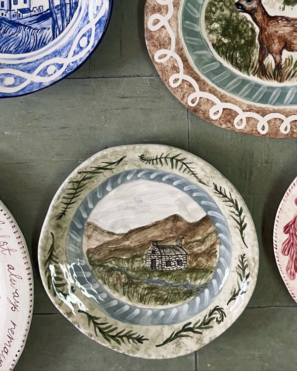 Collection of decorative plates with various designs on a wooden surface