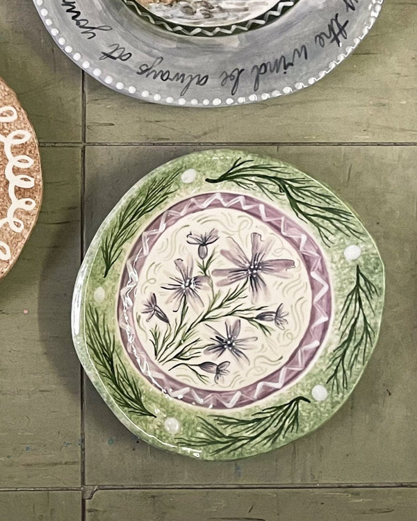 Decorative plate with floral design on a wooden surface