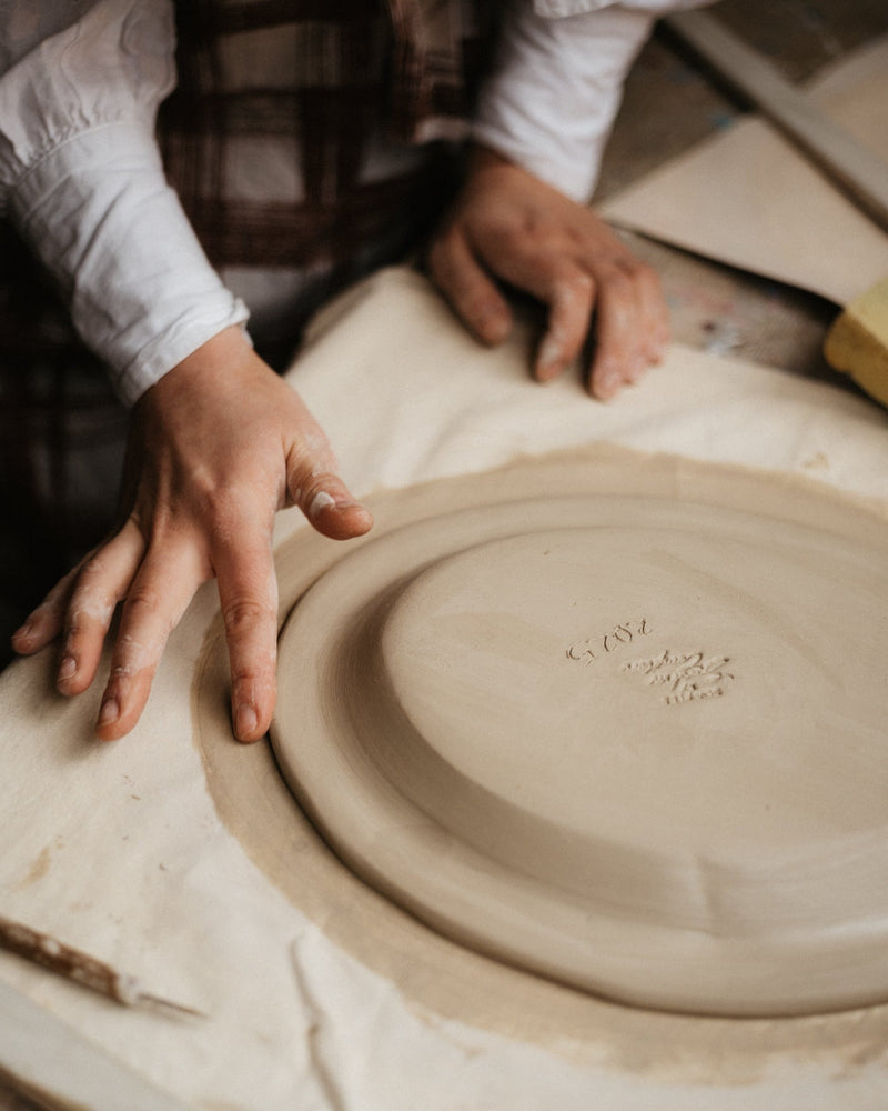 Person working with clay on a pottery wheel