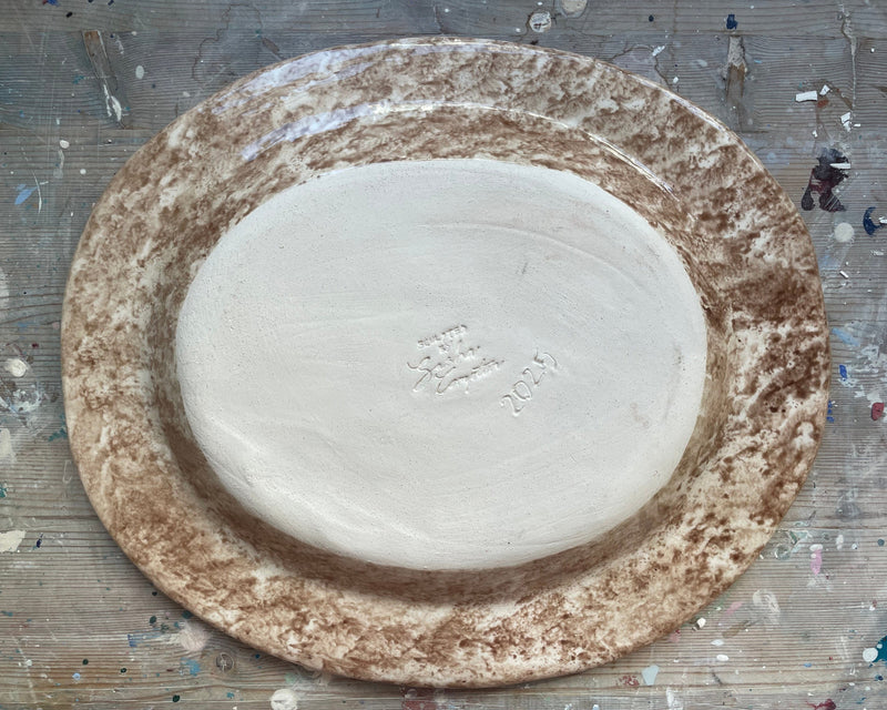 Round ceramic plate with a textured brown rim on a wooden surface