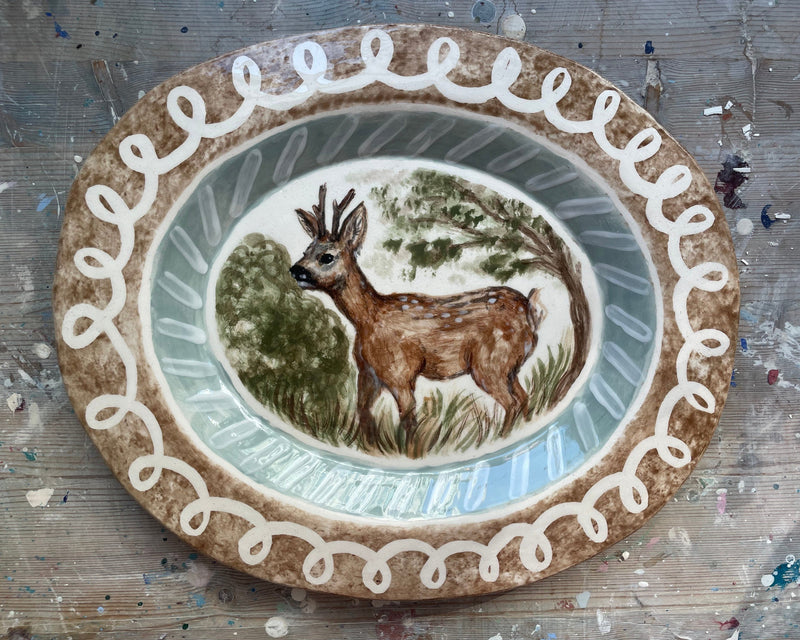 Decorative plate with a deer illustration on a textured surface