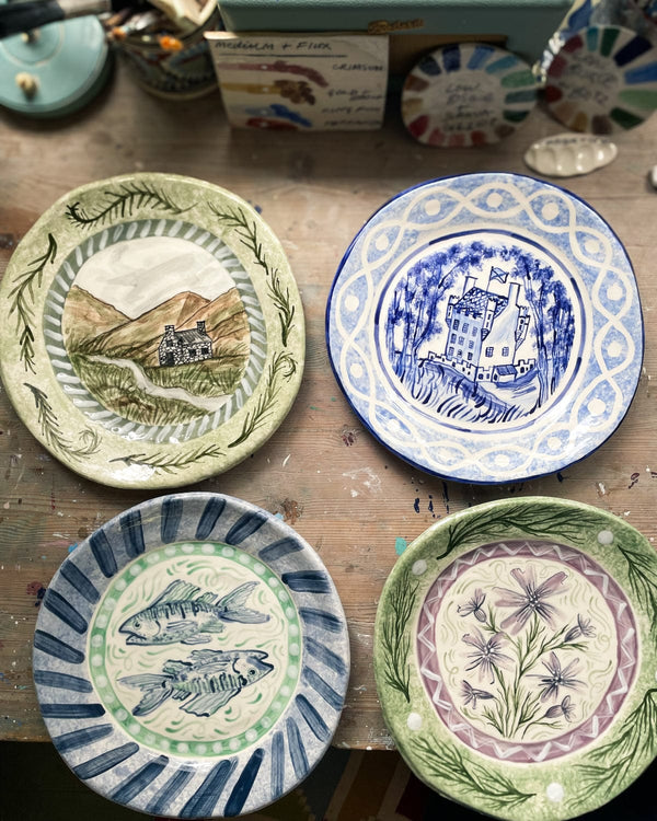 Four decorative plates with different patterns on a wooden surface