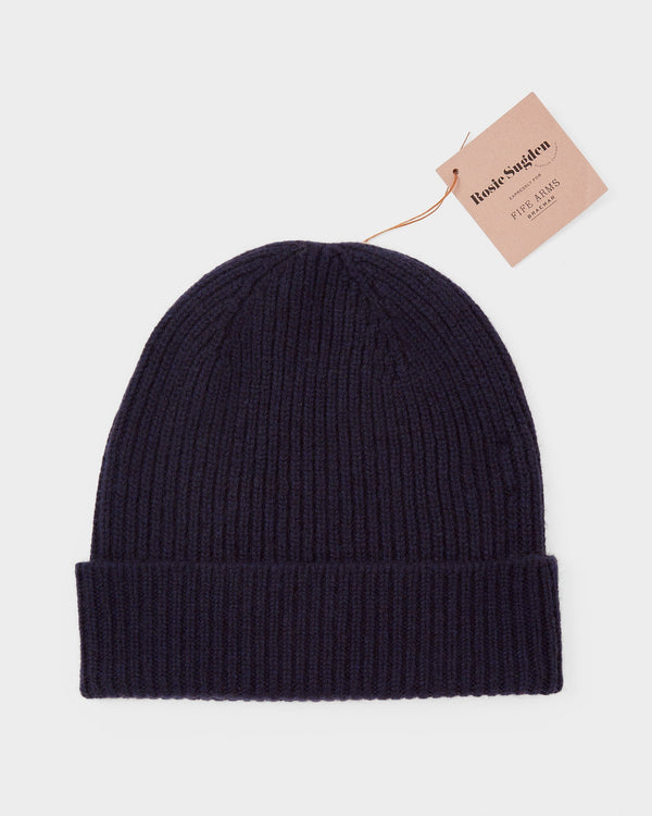 Navy blue knit beanie with a brand tag on a light gray background