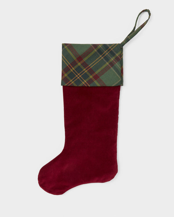 Red Christmas stocking with tartan trim on a white background